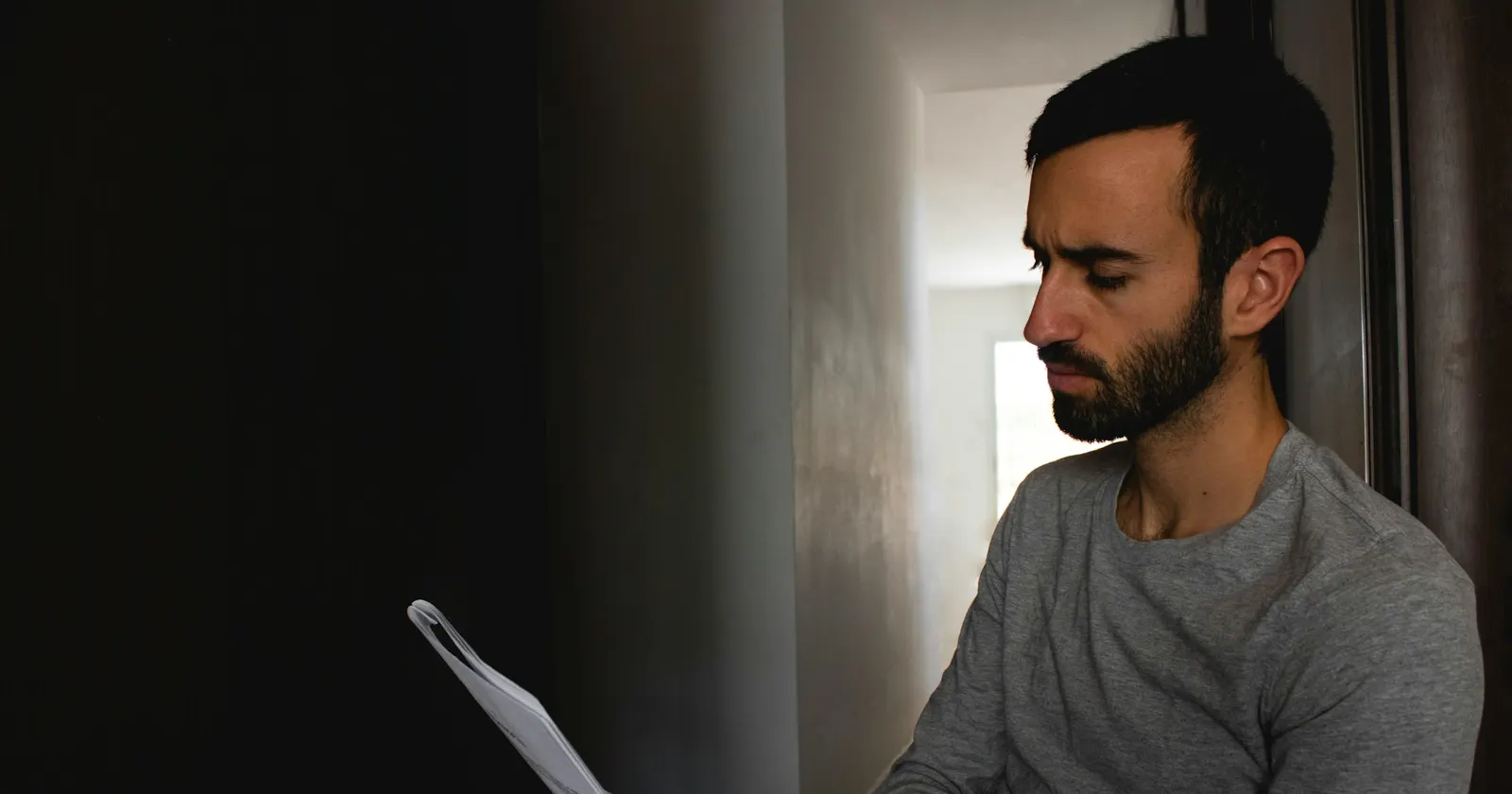 Un comédien seul lit son texte près d’une fenêtre