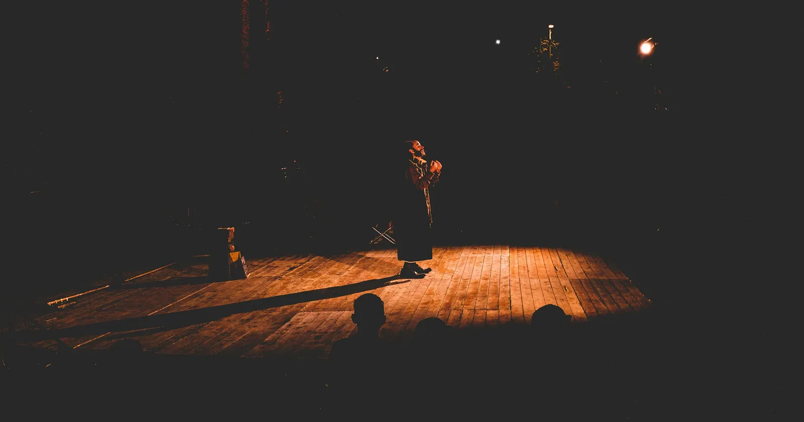 Une personne seule sur un plateau de théâtre, sous une poursuite